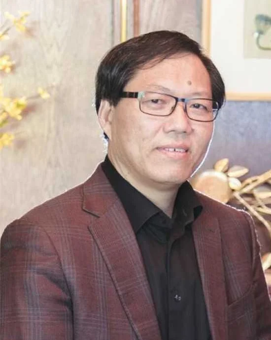 Tongnian Zhuo, Dr. TCM, seated in his clinic