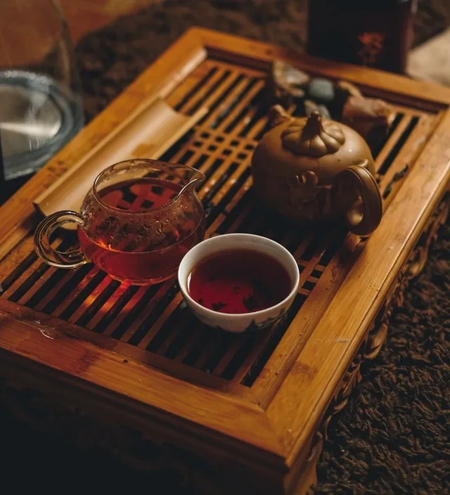 A teapot and cups on a wooden tea tray